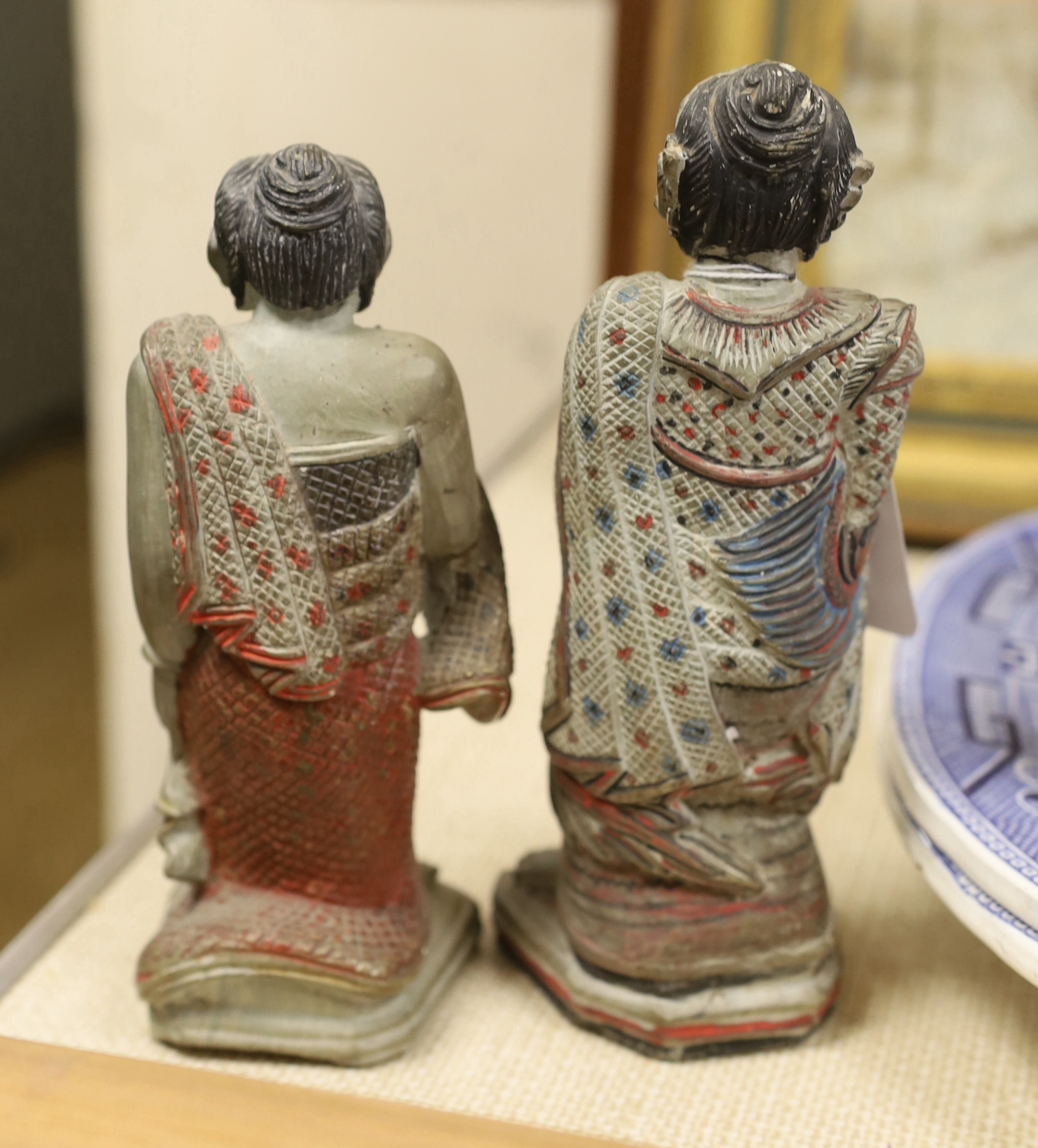 An Indonesian hand painted calendar and two similar figures, tallest 21cm